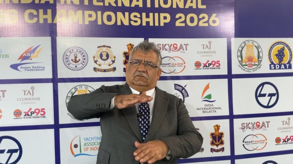 Person gesturing at event backdrop.